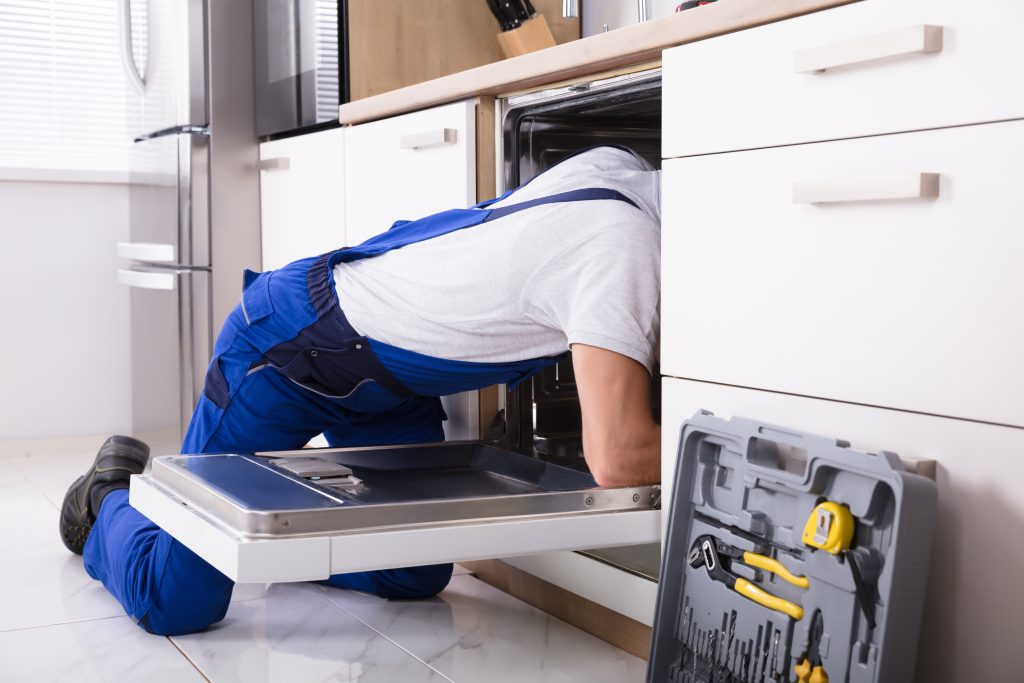 Plumber Fixing A Dishwasher