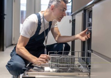 Plumber Fixing A Dishwasher