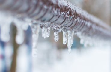 frozen icicles after rain on the pipe