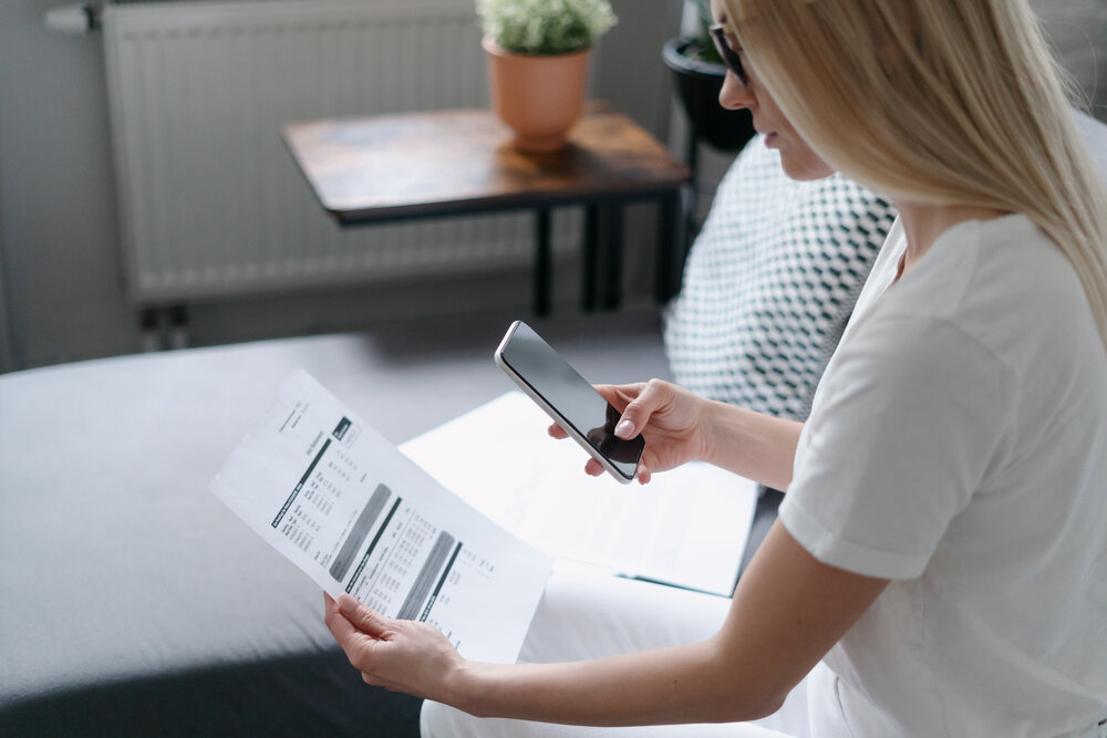 woman scanning water bill with cell phone