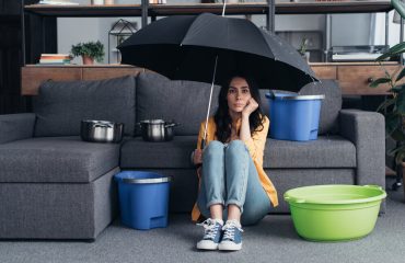 Pensive brunette girl sitting on floor with umbrella