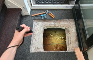Indoor crawl space access hatch with plumbing exposed